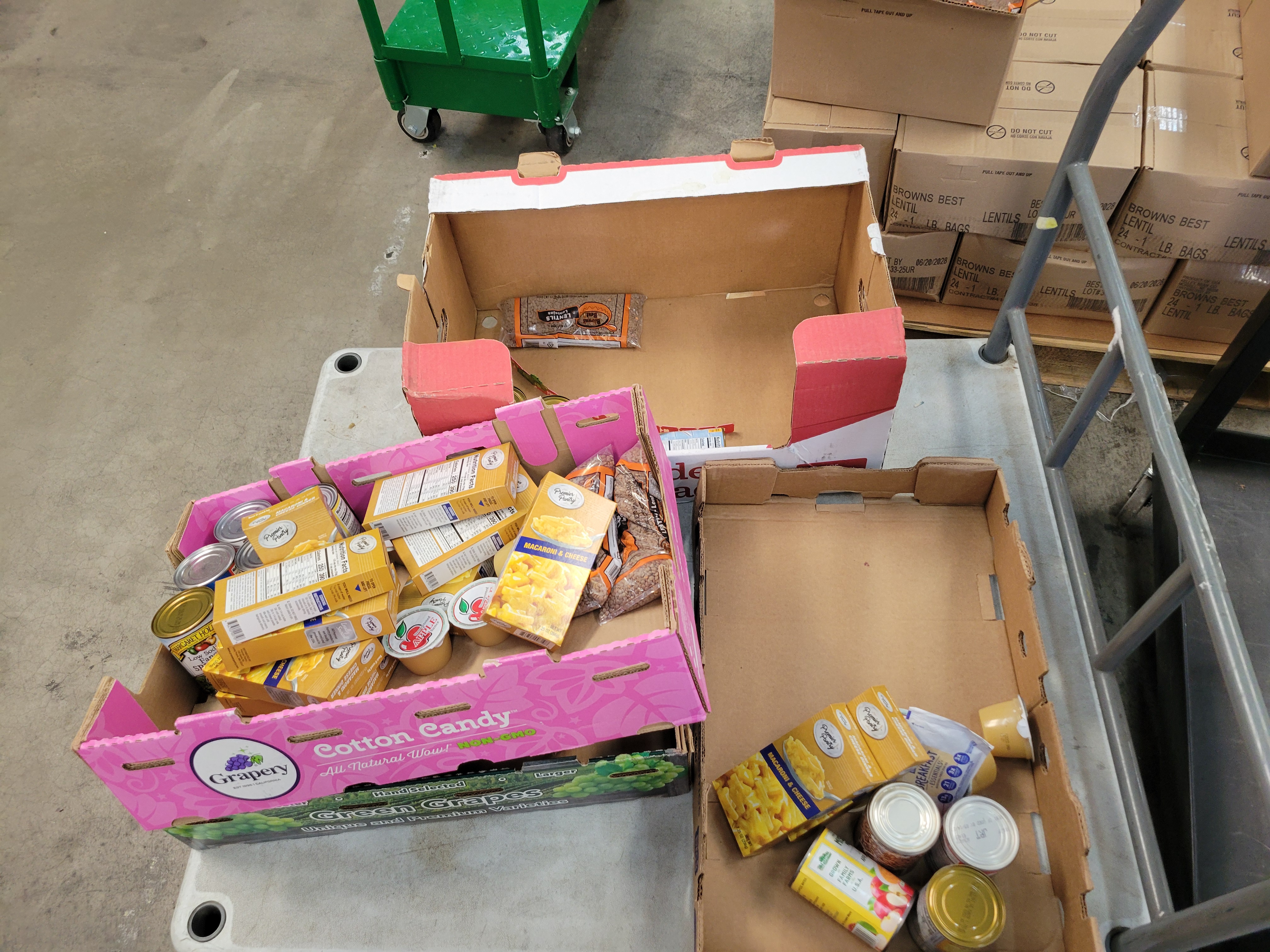 Different foods in three fruit boxes on truck cart.
